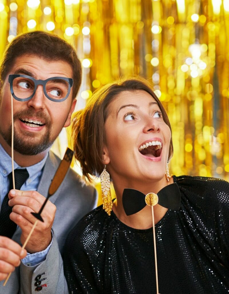 Couple over gold with photo booth accessories on party